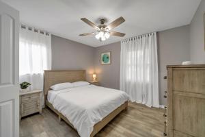 a bedroom with a bed and a ceiling fan at Magnolia - Family-Friendly Comforts, TVs, Grill & Just Steps to the Beach! in Fort Walton Beach