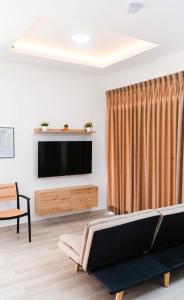 uma sala de estar com uma televisão de ecrã plano e um sofá em Casa La Merced em Tarapoto