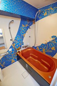 a red tub in a bathroom with blue and yellow tiles at Hotel Sanriiott Kitahama - Vacation STAY 33498v in Osaka