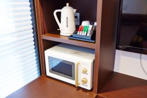 a microwave sitting on a shelf in a cabinet at Hotel Sanriiott Kitahama - Vacation STAY 33596v in Osaka