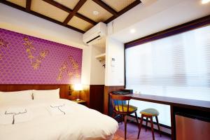 een slaapkamer met een bed, een bureau en een raam bij Hotel Sanriiott Kitahama - Vacation STAY 33596v in Osaka