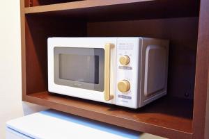 a white microwave oven sitting on a shelf at Hotel Sanriiott Kitahama - Vacation STAY 33524v in Osaka +3 photos