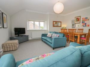 a living room with a blue couch and a table at Lake House Loft in Windermere