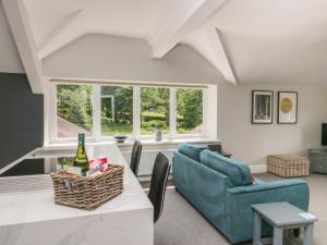 uma sala de estar com uma mesa, cadeiras e janelas em Lake House Loft em Windermere