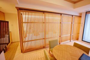 Camera con parete divisoria in legno, tavolo e sedie. di Hotel Sanriiott Kitahama - Vacation STAY 33509v ad Osaka