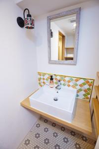 bagno con lavandino bianco e specchio di Hotel Sanriiott Kitahama - Vacation STAY 33509v ad Osaka