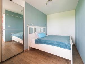 Un dormitorio pequeño con una cama y un espejo. en Schöner Bungalow in Poel in Strandnähe, en Fährdorf