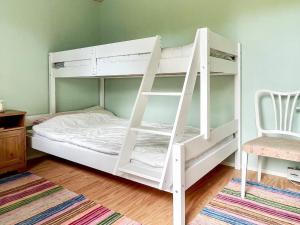 a white bunk bed with a ladder in a room at 8 person holiday home in Mönsterås-By Traum in Mönsterås