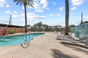 a swimming pool with palm trees and a fence at Citrus Blossom with Pool and Parking in Phoenix