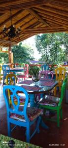 una mesa con sillas coloridas, una mesa y una mesa con sillas en Finca San Miguel Filandia en Filandia