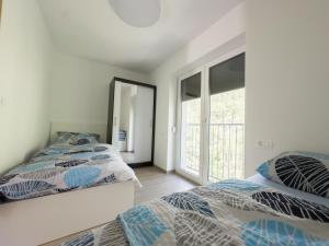 a bedroom with two beds and a mirror at APARTMAJI SILVA in Slap ob Idrijci