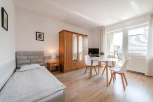 1 dormitorio con cama, mesa y escritorio en Mario Pokoje - Apartamenty, en Jastarnia