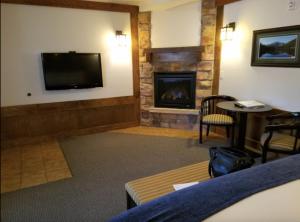 a living room with a fireplace and a tv at The Haber Motel in Estes Park