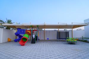 a playground with a slide and a canopy at Bahja Challet in As Suwayq