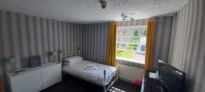 a small bedroom with a bed and a window at Winchester Arms in Trull