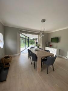 comedor con mesa de madera y sillas en Gorgeous family home 15 mins from City Centre Edinburgh, en Edimburgo