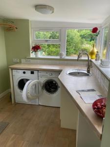 a kitchen with a washing machine and a sink at Gorgeous family home 15 mins from City Centre Edinburgh in Edinburgh