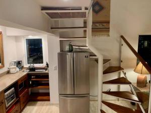 a kitchen with a stainless steel refrigerator and a staircase at Penthouse 1AB on the beach with sea views in Cancún