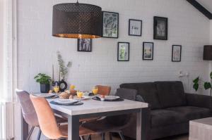 a dining room with a table and a couch at Vakantiehuisje verhuur - Heuvel 35 in Simpelveld