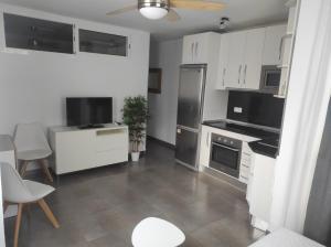 a kitchen with white cabinets and a black refrigerator at Apartamento CANDELA in Fuengirola