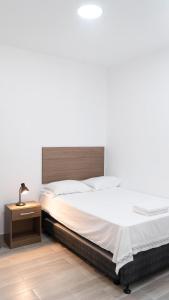 1 dormitorio con 1 cama grande y mesita de noche en Casa La Merced, en Tarapoto