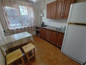 uma cozinha com armários de madeira e um frigorífico branco em 3 кімнатна квартира на вул. Калинова. em Dnipro