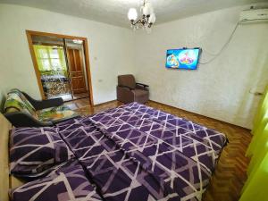 um quarto com uma cama roxa e uma cadeira em 3 кімнатна квартира на вул. Калинова. em Dnipro