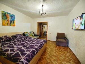um quarto com uma cama e uma cadeira em 3 кімнатна квартира на вул. Калинова. em Dnipro