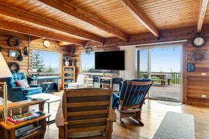a living room with wooden ceilings and a flat screen tv at Port Angeles Blue Mountain Lodge with Bunkhouse in King Hill