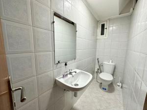 a white bathroom with a sink and a toilet at Rabat, Appartement Neuf en face d'Arribat Center. in Rabat