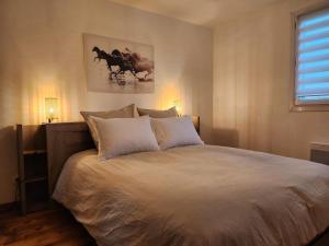 1 dormitorio con 1 cama grande con sábanas blancas en GuestHouse La Costière - logements indépendants - espace piscine jacuzzi en Lunel