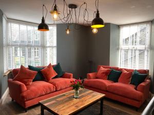 a living room with two red couches and a coffee table at High Street Apartment in Windermere