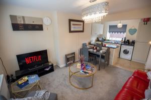 a living room with a couch and a table and a kitchen at OG Tranquil Homes - Contractor & Family Friendly, FREE WiFi & Parking, Laptop friendly, Garden in Sunderland