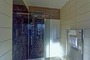 a bathroom with a shower with a glass door at The Shoreline Retreat in Lytham St Annes