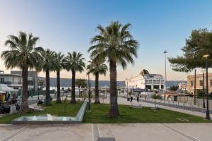 a group of palm trees in a square with buildings at Limani elegant apartments in Souda