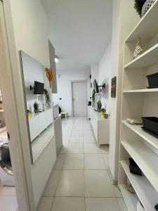 una lavanderia con armadi bianchi e pavimento piastrellato bianco di La Casa di Mia a Cagliari