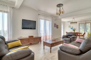 a living room with couches and a flat screen tv at Seaview Villa Lavanda with pool in Budva