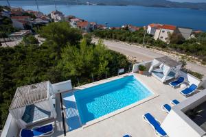 uma villa com piscina e vista para a água em Villa Mare em Klek