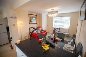 cocina y sala de estar con sofá rojo en OG Tranquil Homes - Contractor & Family Friendly, FREE WiFi & Parking, Laptop friendly, Garden, en Sunderland