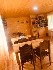 een eetkamer met een houten tafel en stoelen bij Ushba Cottages in Mazeri