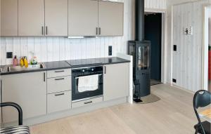 una cucina con armadi bianchi e piano cottura di Cozy Apartment In Fl With Kitchen a Flå