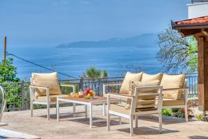 Seaview Villa Lavanda with pool في بودفا: كرسيين وطاولة على فناء مع المحيط