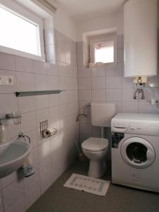 a bathroom with a washing machine and a sink at Marianna Apartman in Gyenesdiás