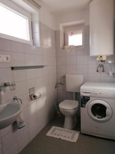 ギェネシュディアーシュにあるMarianna Apartmanのバスルーム(洗濯機、シンク付)