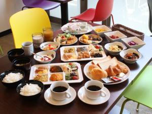 uma mesa coberta com pratos de comida e chávenas de café em APA Hotel Toyama-Ekimae Minami em Toyama