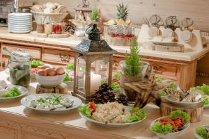 a buffet with plates of food on a table at Góralski Gościniec & SPA in Poronin