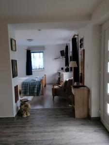 a bedroom with a bed and a chair in a room at Marianna Apartman in Gyenesdiás