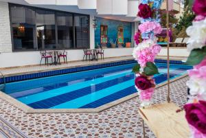 安塔利亞的住宿－AZUU BOHEM HOTEL，游泳池旁的游泳池,有粉红色的花朵