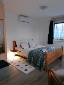 a bedroom with a bed and a window at Marianna Apartman in Gyenesdiás