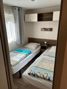 two twin beds in a room with a window at Camping les Cigales - Mobil-home 4/6 personnes in Le Muy